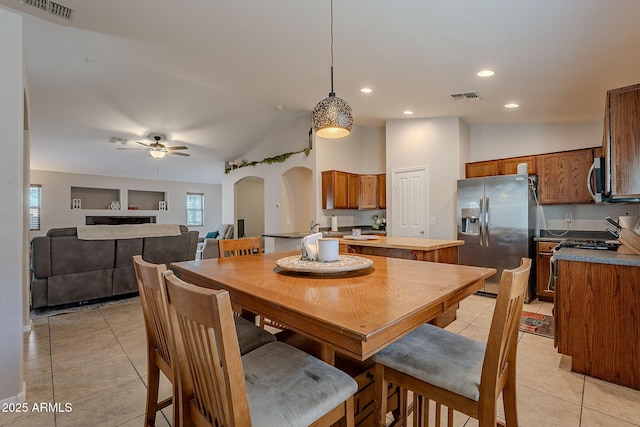 tiled dining space with lofted ceiling and ceiling fan