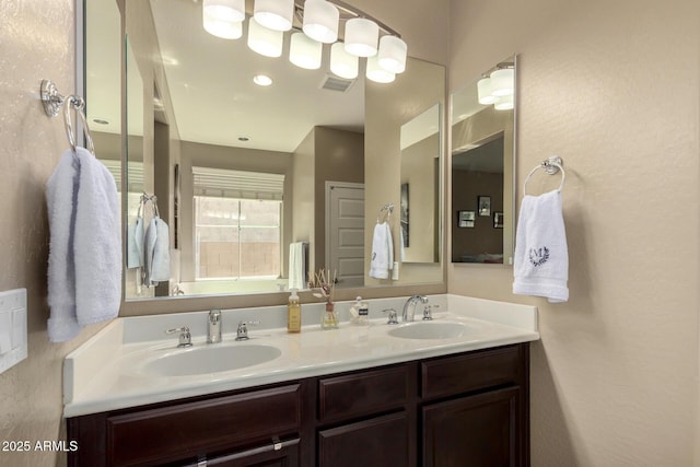 full bath with a sink, double vanity, and visible vents
