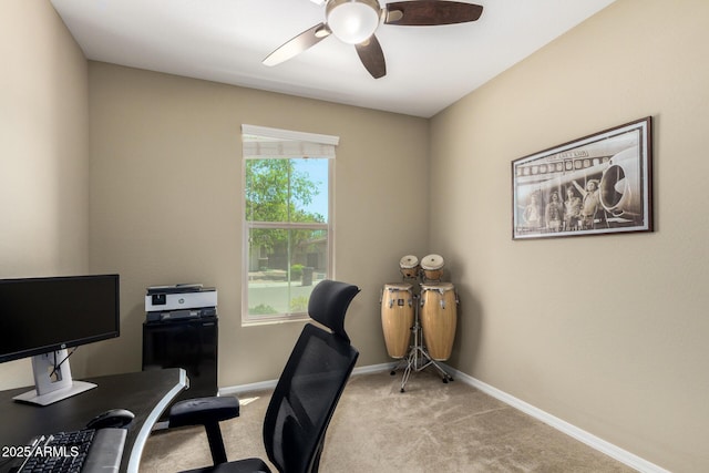carpeted home office with baseboards and a ceiling fan