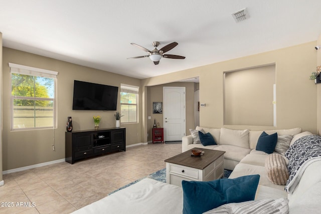living area with visible vents, a ceiling fan, baseboards, and light tile patterned floors