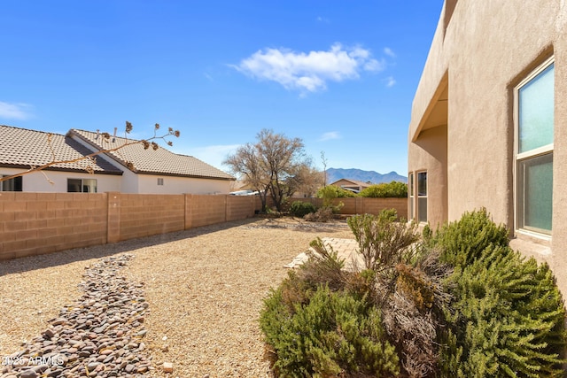 view of yard featuring a fenced backyard and a mountain view