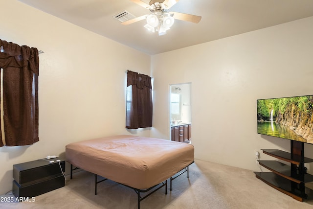 bedroom featuring light carpet, connected bathroom, visible vents, and a ceiling fan