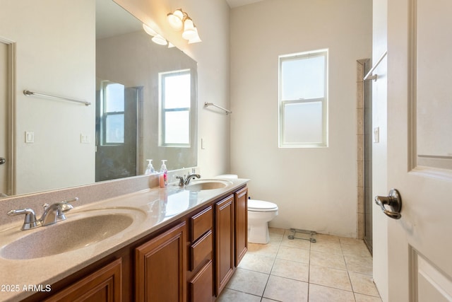 full bath featuring double vanity, a sink, toilet, and tile patterned floors