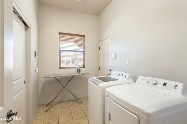 laundry room featuring light tile patterned floors, laundry area, and separate washer and dryer