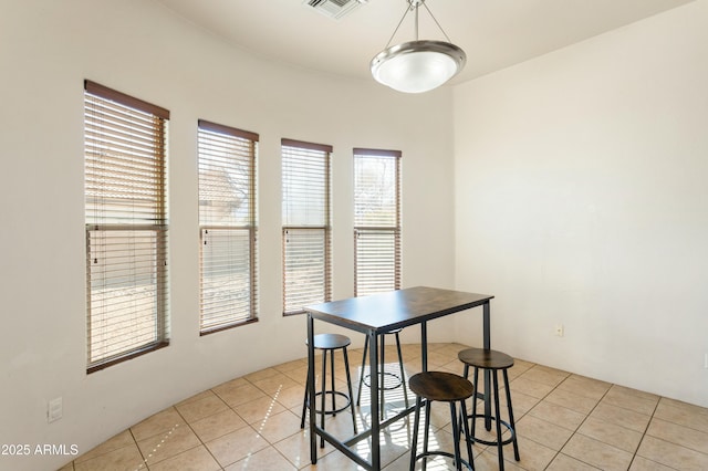 dining space with light tile patterned floors and visible vents