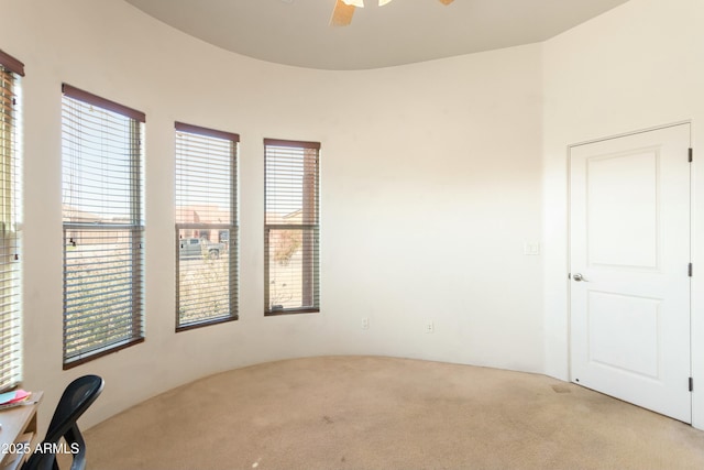 spare room with ceiling fan and light colored carpet