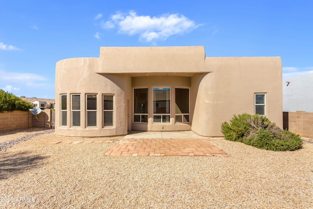 rear view of property with a patio, a fenced backyard, and stucco siding