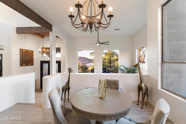 dining area featuring ceiling fan with notable chandelier, beam ceiling, and light hardwood / wood-style floors