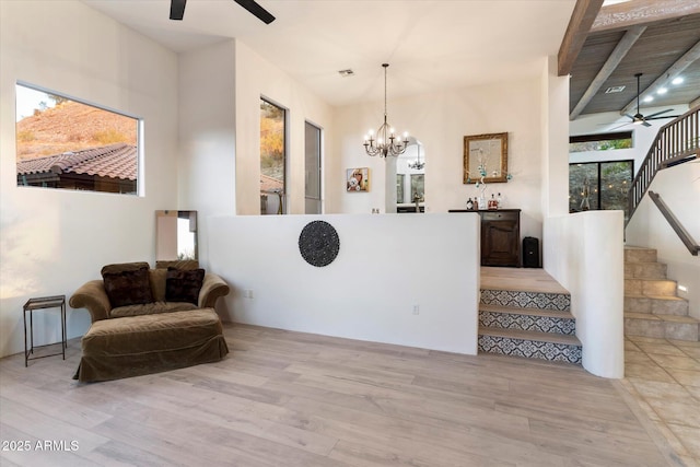 sitting room with ceiling fan with notable chandelier and light wood-type flooring