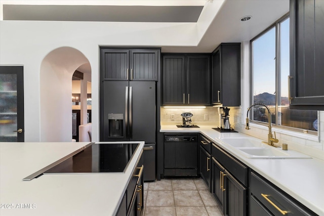 kitchen featuring sink, tasteful backsplash, light tile patterned floors, a mountain view, and black appliances