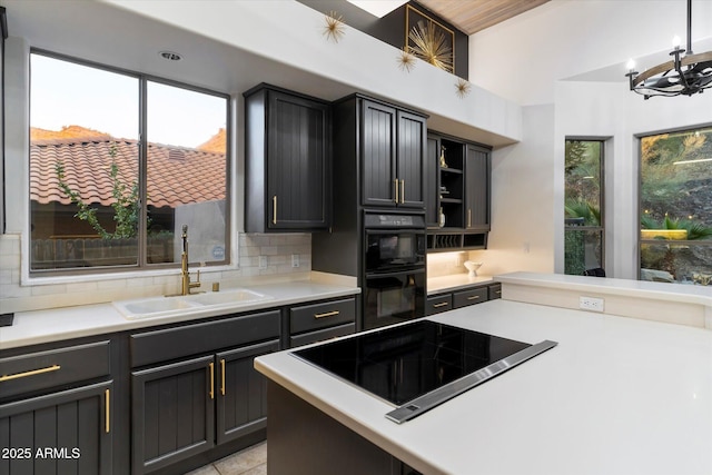 kitchen with tasteful backsplash, plenty of natural light, sink, and black appliances