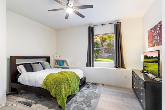 bedroom with ceiling fan and light hardwood / wood-style floors