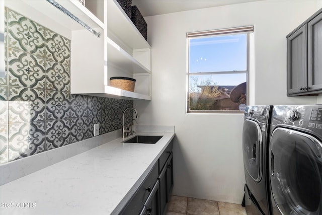 laundry room featuring cabinets, washer and dryer, sink, and light tile patterned floors