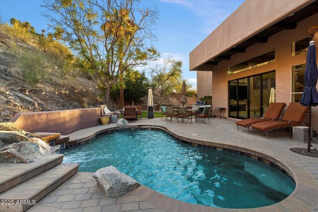 view of swimming pool with a patio and pool water feature