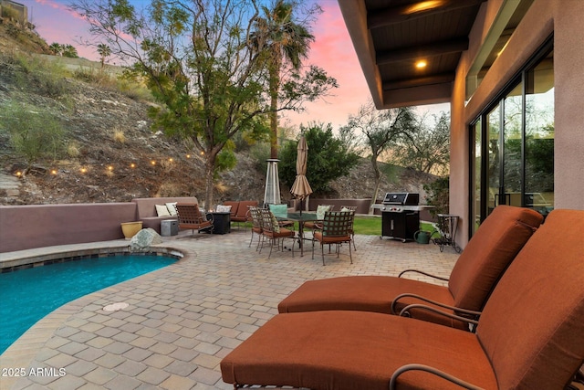 patio terrace at dusk featuring area for grilling