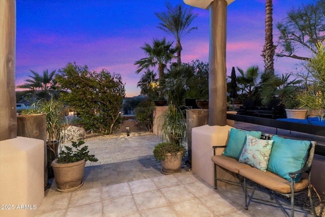 patio terrace at dusk featuring an outdoor living space