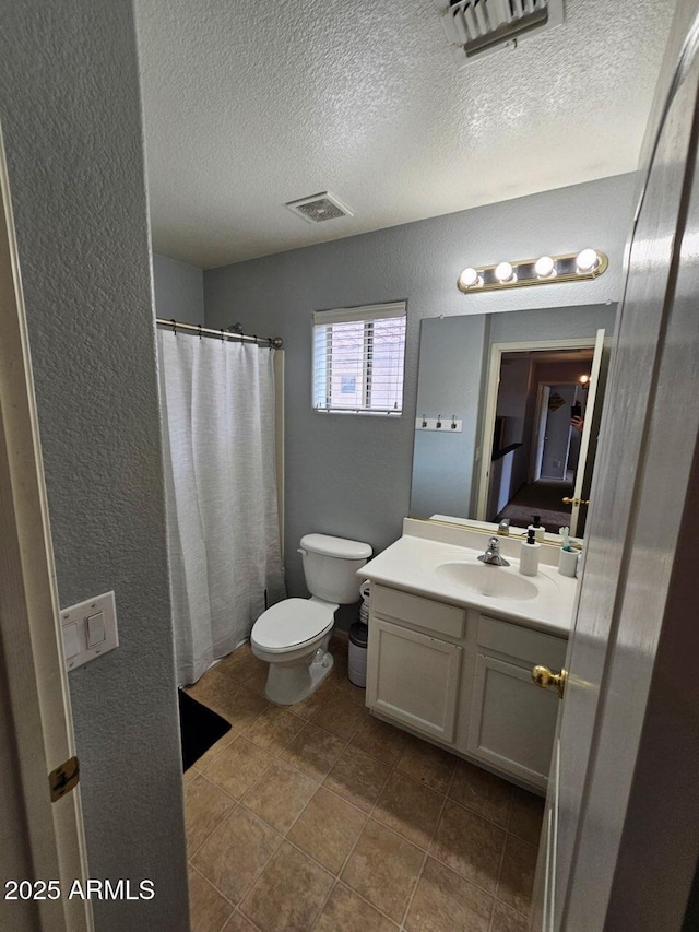 2514 W Big Oak St, Phoenix, AZ 85085 - bathroom with a textured ceiling, visible vents, vanity, toilet, and a textured wall