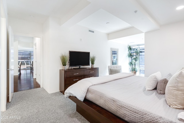 bedroom featuring visible vents, beamed ceiling, and carpet flooring