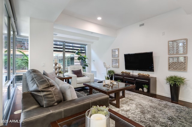 living room with recessed lighting, visible vents, baseboards, and wood finished floors