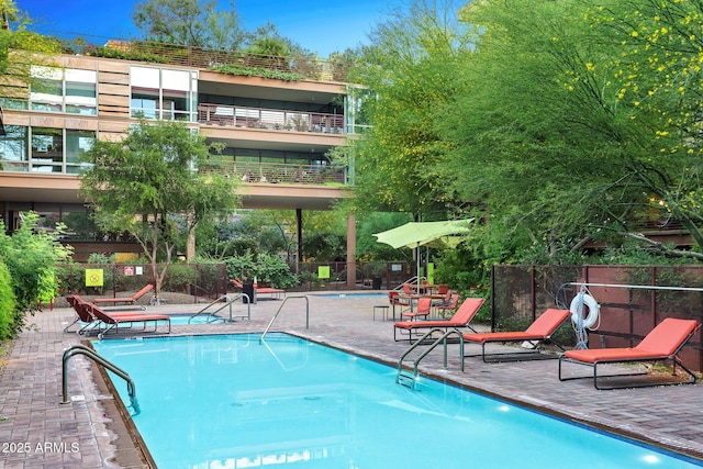 community pool featuring fence and a patio