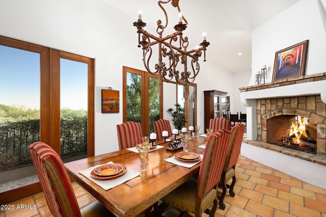 40039 N 107th Pl, Scottsdale, AZ 85262 - dining space with a towering ceiling, a chandelier, a stone fireplace, light tile patterned floors, and french doors