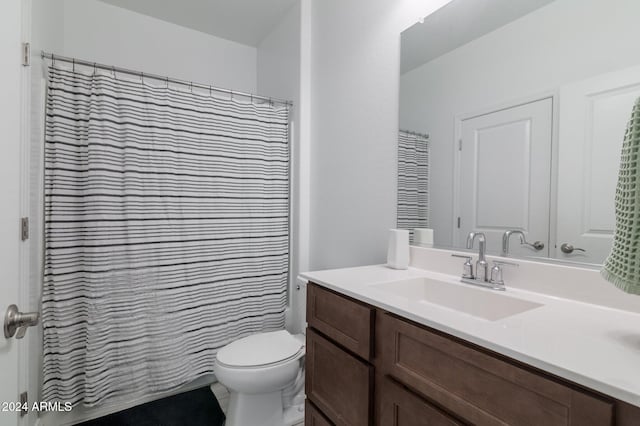 bathroom with vanity, curtained shower, and toilet