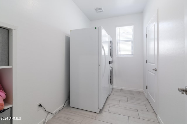 laundry area with stacked washing maching and dryer