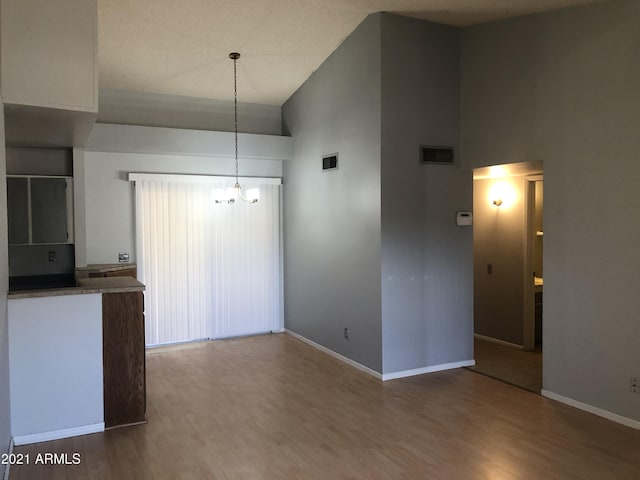 4042 E Carson Rd, Phoenix, AZ 85042 - unfurnished dining area featuring high vaulted ceiling, a chandelier, and wood finished floors