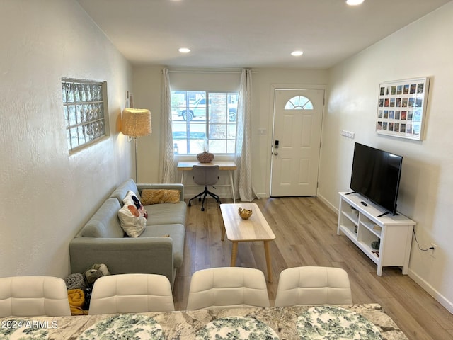 living area featuring baseboards, light wood finished floors, and recessed lighting