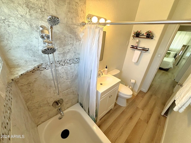 full bathroom featuring a textured wall, toilet, wood finished floors, vanity, and shower / bath combo