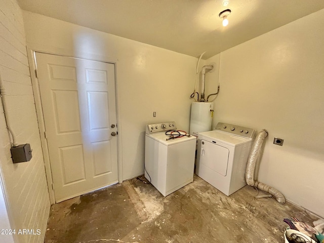 clothes washing area with independent washer and dryer, laundry area, and gas water heater