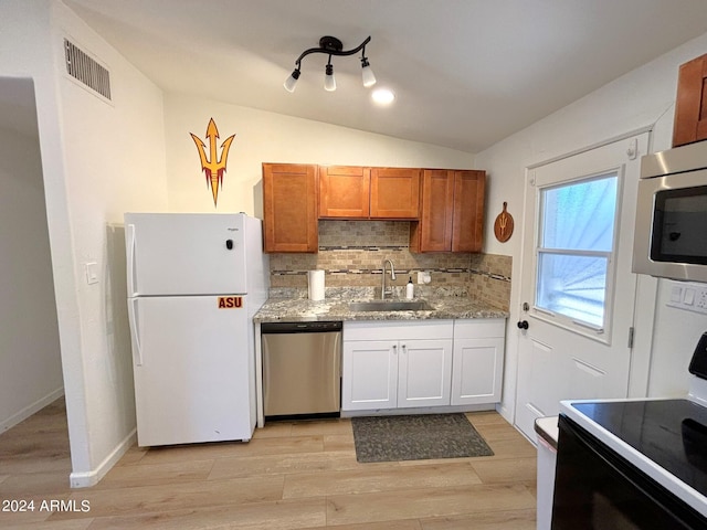 kitchen with light stone counters, stainless steel appliances, a sink, visible vents, and decorative backsplash