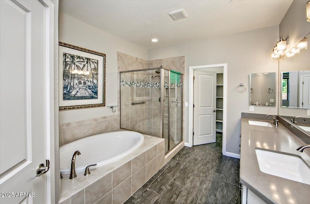 7769 E Lavender Loop, Prescott Valley, AZ 86315 - full bath featuring a garden tub, double vanity, a shower stall, and wood finished floors