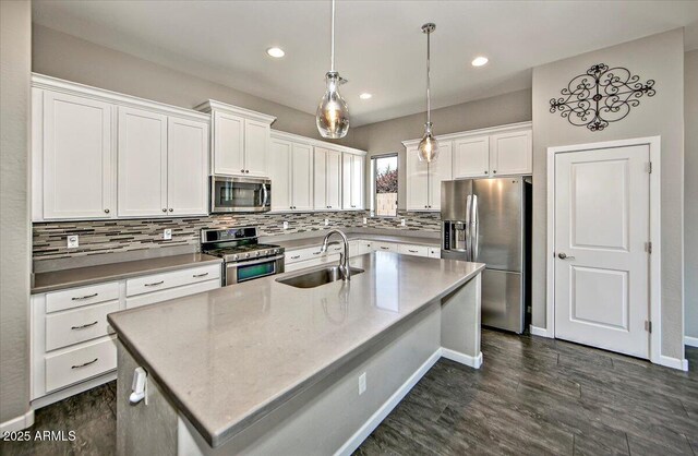 7769 E Lavender Loop, Prescott Valley, AZ 86315 - kitchen with appliances with stainless steel finishes, a sink, dark wood-style floors, white cabinetry, and backsplash