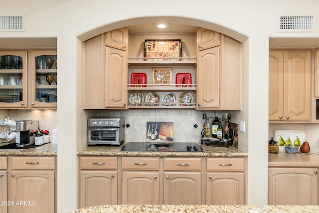 kitchen featuring light brown cabinetry and tasteful backsplash