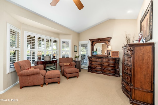 living area featuring ceiling fan, carpet floors, and lofted ceiling