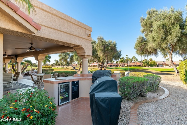 view of patio / terrace featuring an outdoor kitchen, ceiling fan, and beverage cooler