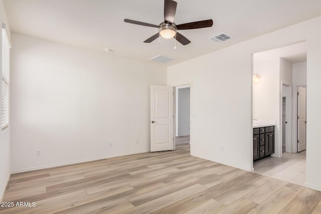 spare room featuring baseboards, light wood-style floors, ceiling fan, and visible vents