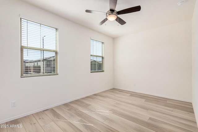 unfurnished room featuring baseboards, light wood-type flooring, and ceiling fan