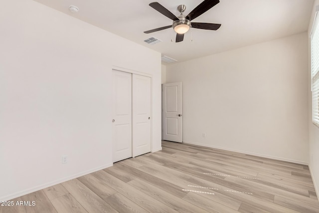 empty room featuring baseboards, visible vents, ceiling fan, and light wood-type flooring