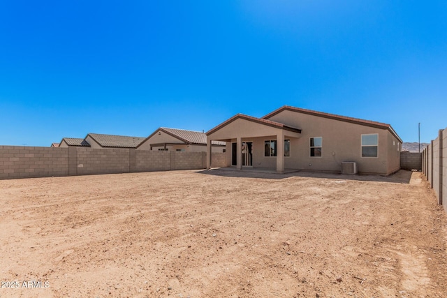rear view of house featuring a tile roof, central air condition unit, stucco siding, a fenced backyard, and a patio