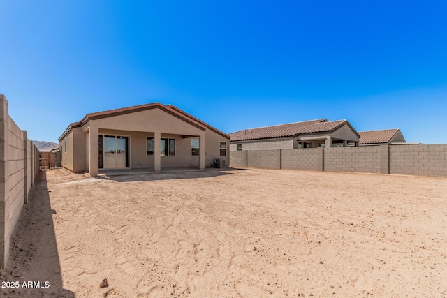 back of property with central AC unit, a patio, a fenced backyard, a tile roof, and stucco siding