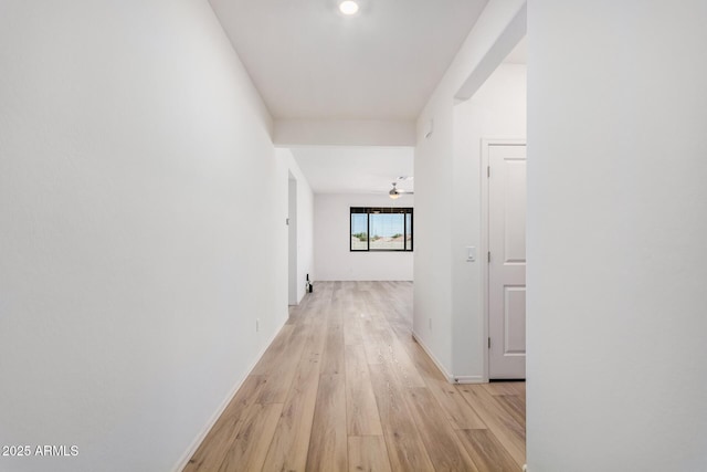 corridor featuring baseboards and light wood-style floors