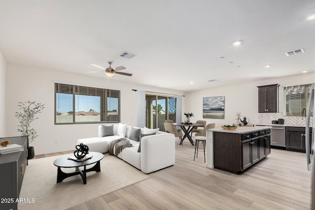 living area featuring ceiling fan, visible vents, recessed lighting, and light wood finished floors