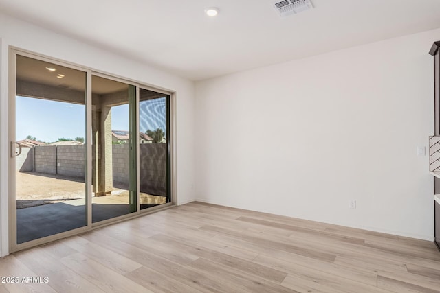 empty room with light wood finished floors, baseboards, visible vents, and recessed lighting