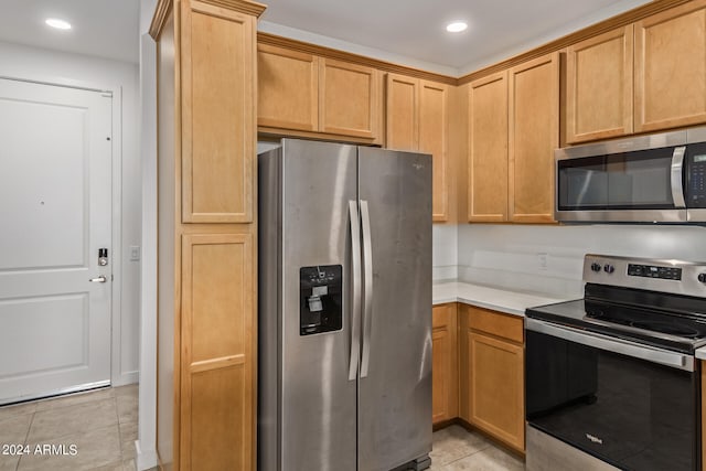 kitchen with appliances with stainless steel finishes and light tile flooring