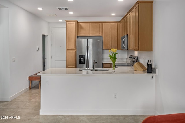 kitchen with sink, light tile floors, and stainless steel appliances