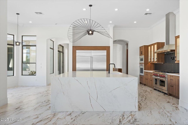 3354 E Jaeger Cir, Mesa, AZ 85213 - kitchen with high quality appliances, arched walkways, wall chimney range hood, light marble finish floors, and ornamental molding