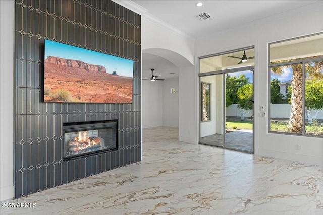 3354 E Jaeger Cir, Mesa, AZ 85213 - unfurnished living room with ceiling fan, marble tiled floors, a glass covered fireplace, plenty of natural light, and crown molding