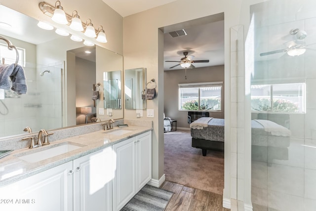 bathroom with tiled shower, vanity, hardwood / wood-style flooring, and ceiling fan